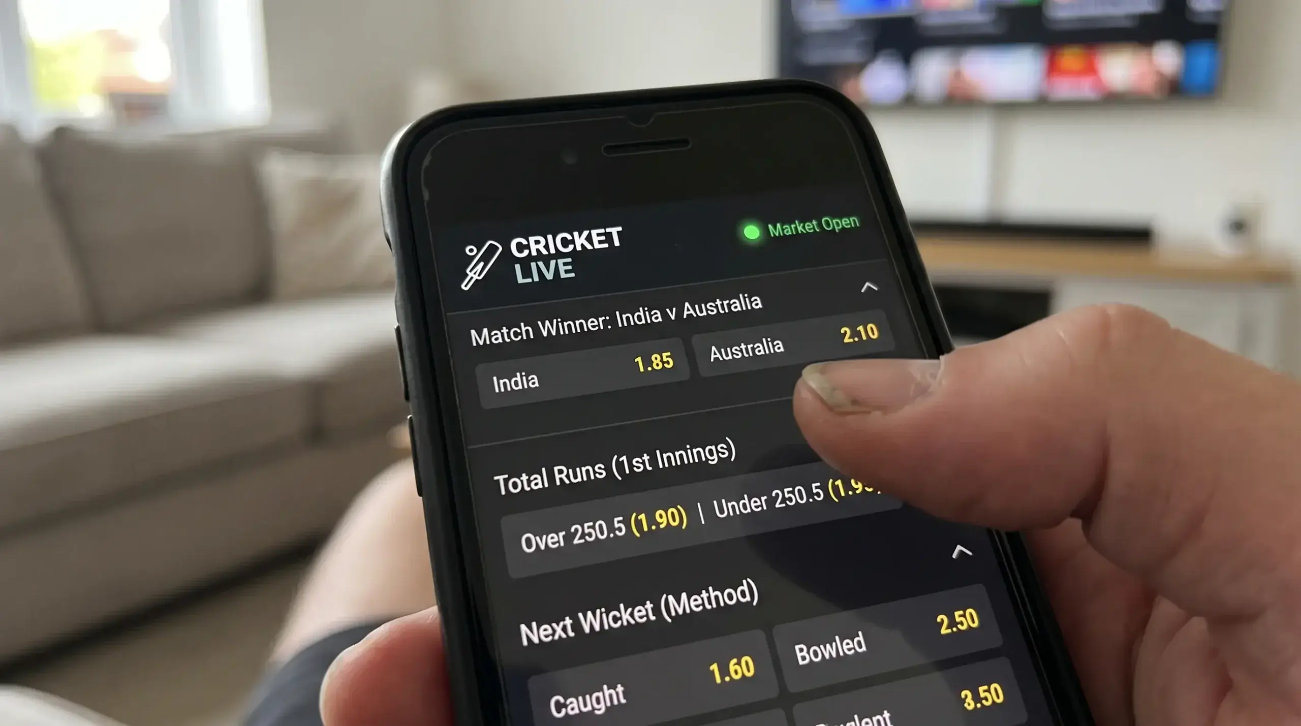 Smartphone displaying live in-play cricket betting odds with market status indicator