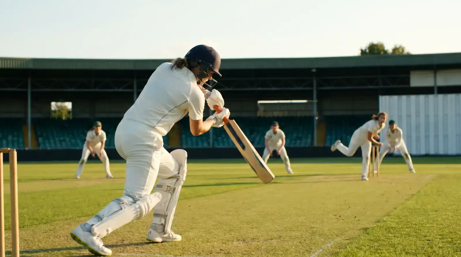 Women's cricket match action with batter and bowler